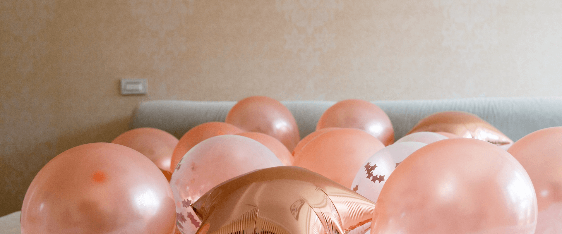 Balões rosas em cima da cama.
